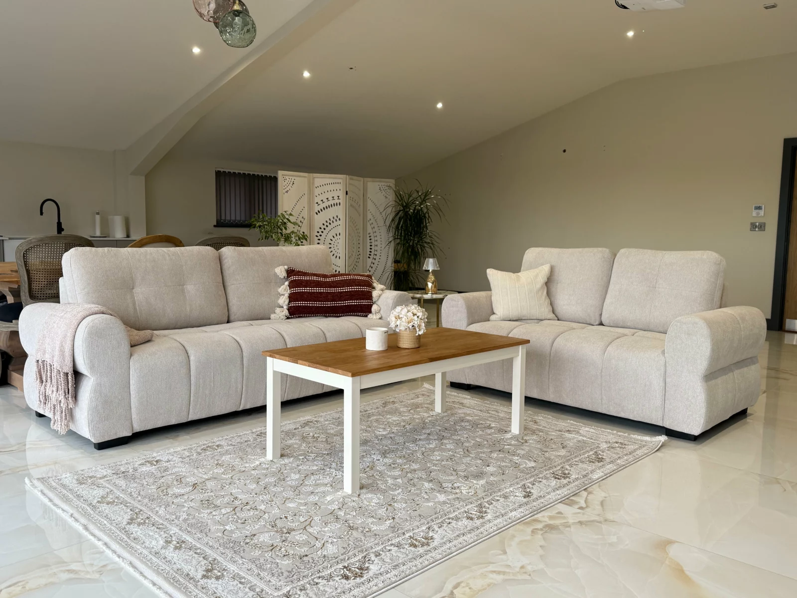 Two cream sofas and a coffee table in a bright open plan living room
