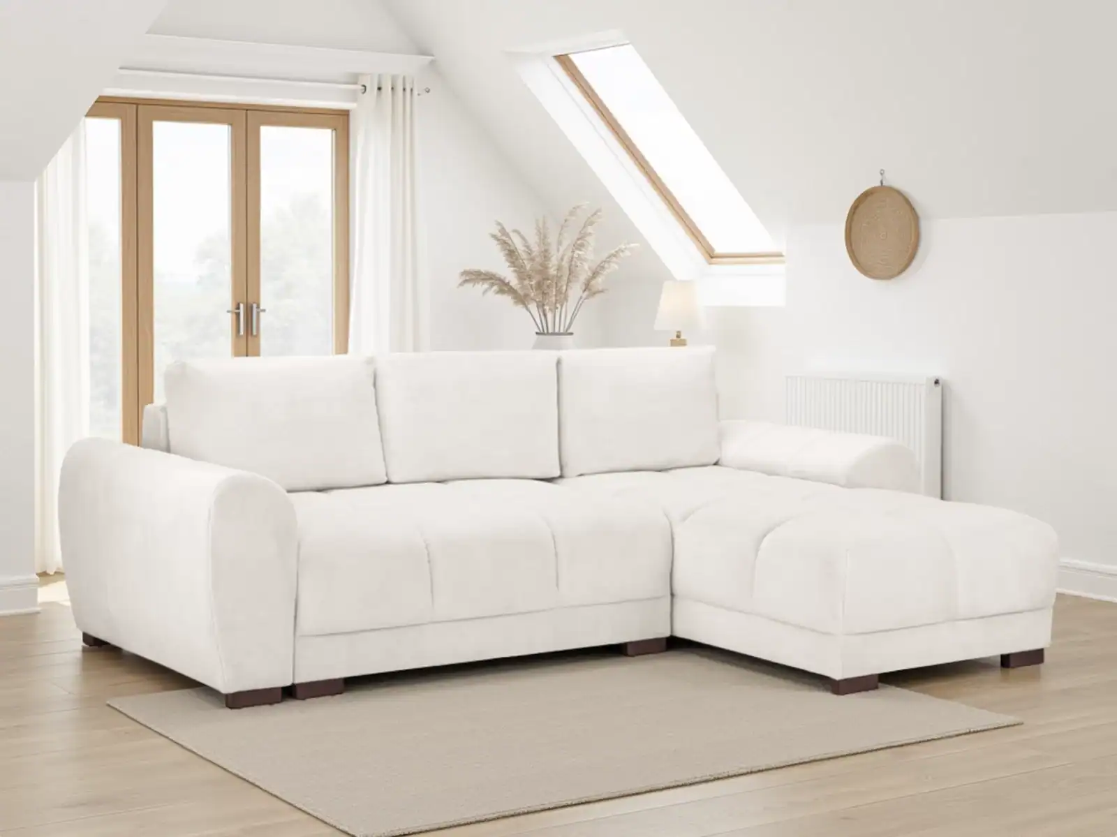 A corner sofa in a loft room with a sloped ceiling and roof window